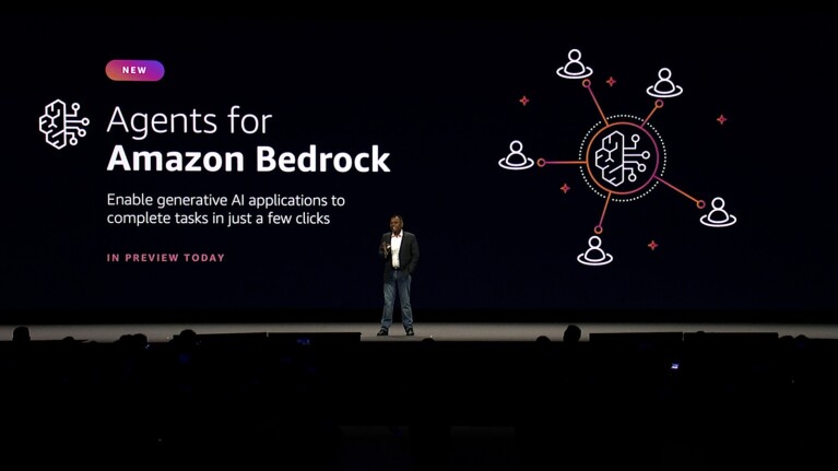 A photo of VP Swami Sivasubramanian speaking on stage at AWS Summit New York. Behind him is a screen that states, "Agents for Amazon Bedrock".
