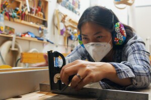 A woman works with wood in her studio