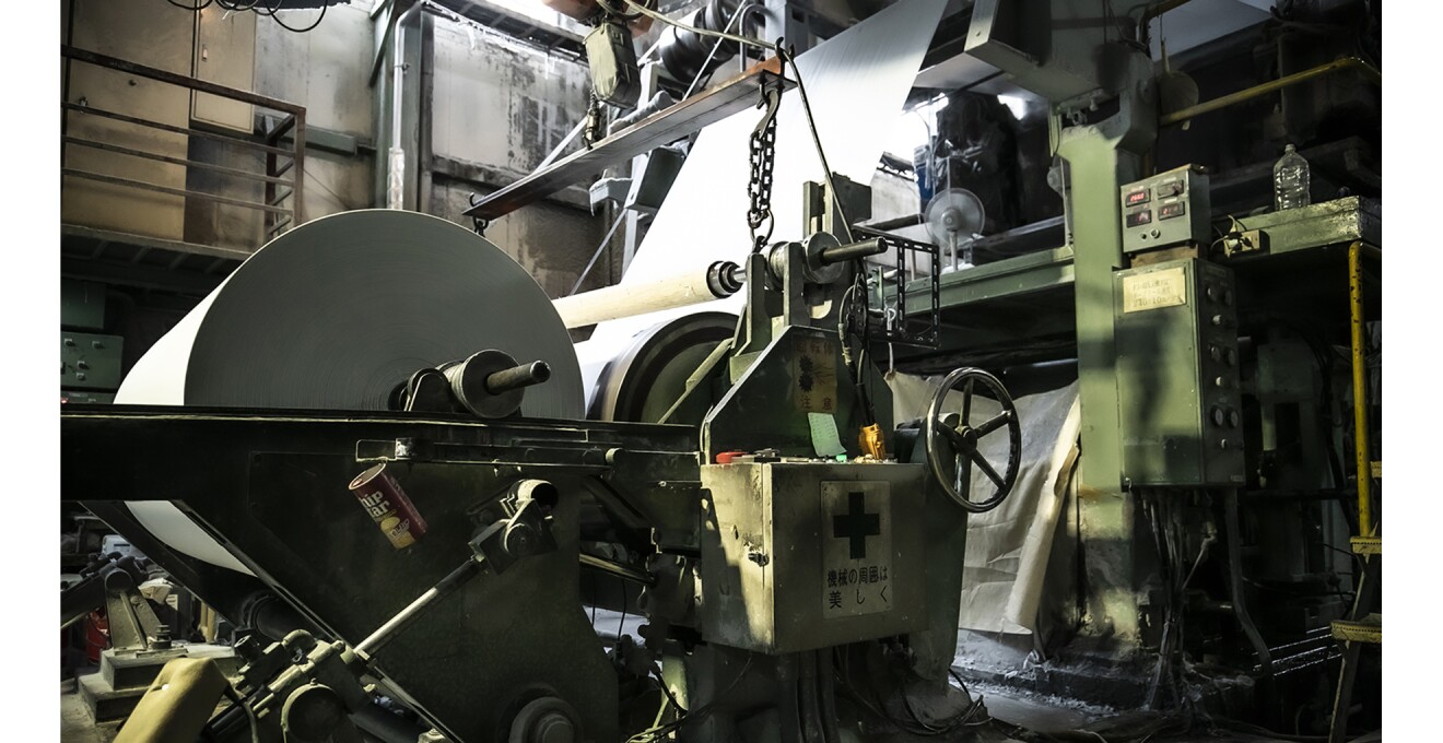 工場内の巨大な機械と巨大なロール紙
