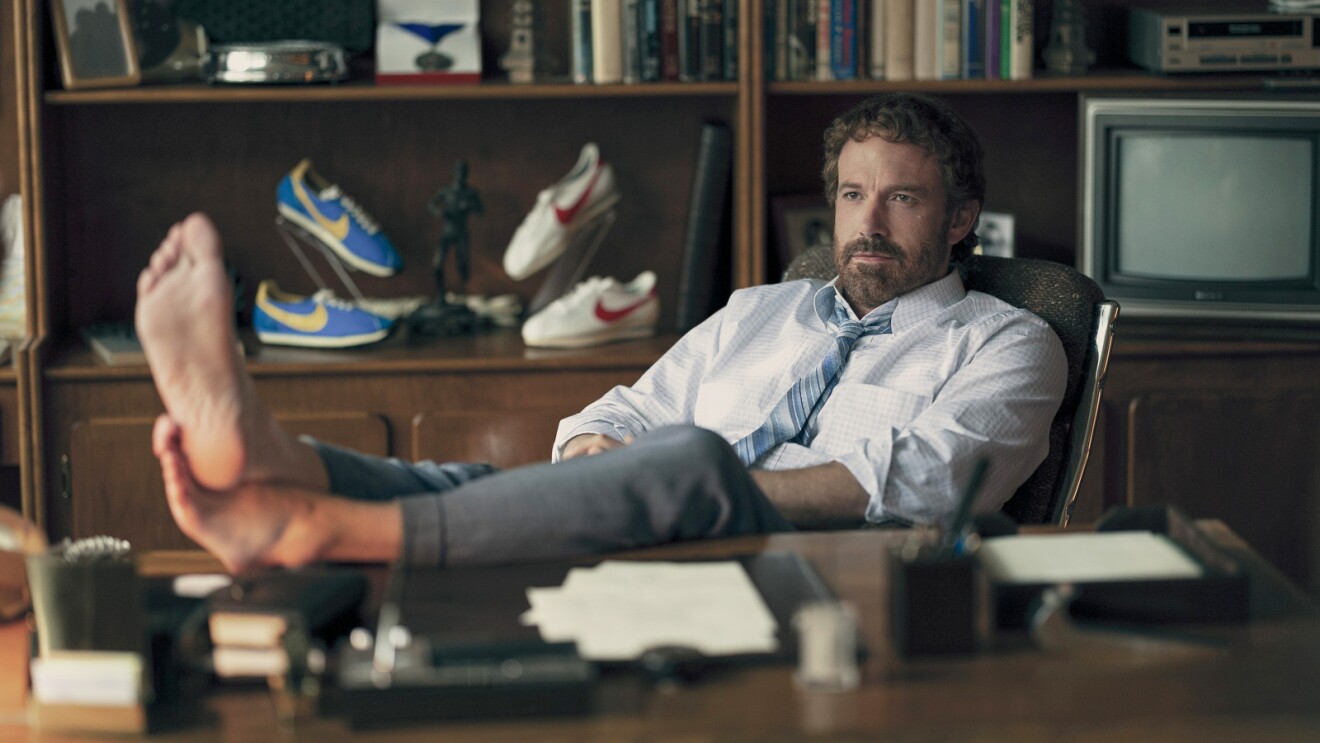 Image of a man putting his feet up on his desk.