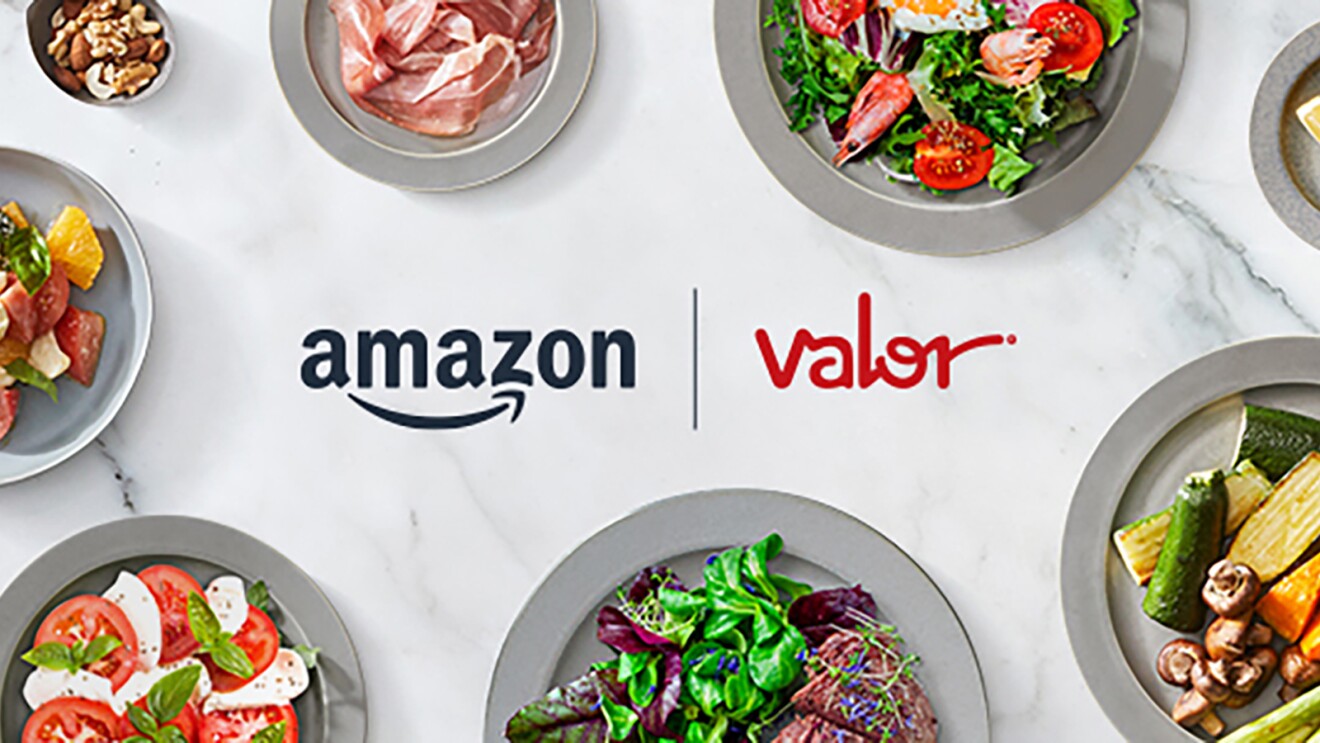 白とグレーの大理石調の背景。中央にAmazonとバローのロゴが横並びで配置され、その周りを8枚のグレーの皿が取り囲む。各皿には野菜サラダ、薄切りの生ハム、ナッツ類、カットフルーツの盛り合わせ、スライストマトとモッツァレラチーズ、葉物野菜と肉料理、ズッキーニときのこのソテーなどが盛り付けられている。