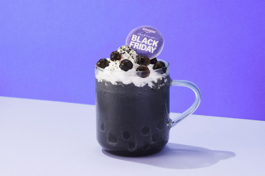 ガラスのマグカップに黒いドリンクが入り、その上にホイップクリームと黒いタピオカが載っている Black Fridayと書かれたカード