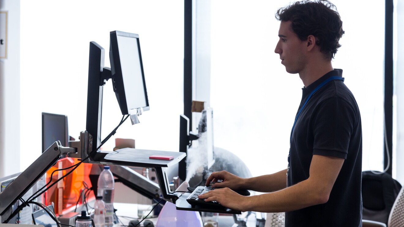 Man working on his computer at a standing desk 