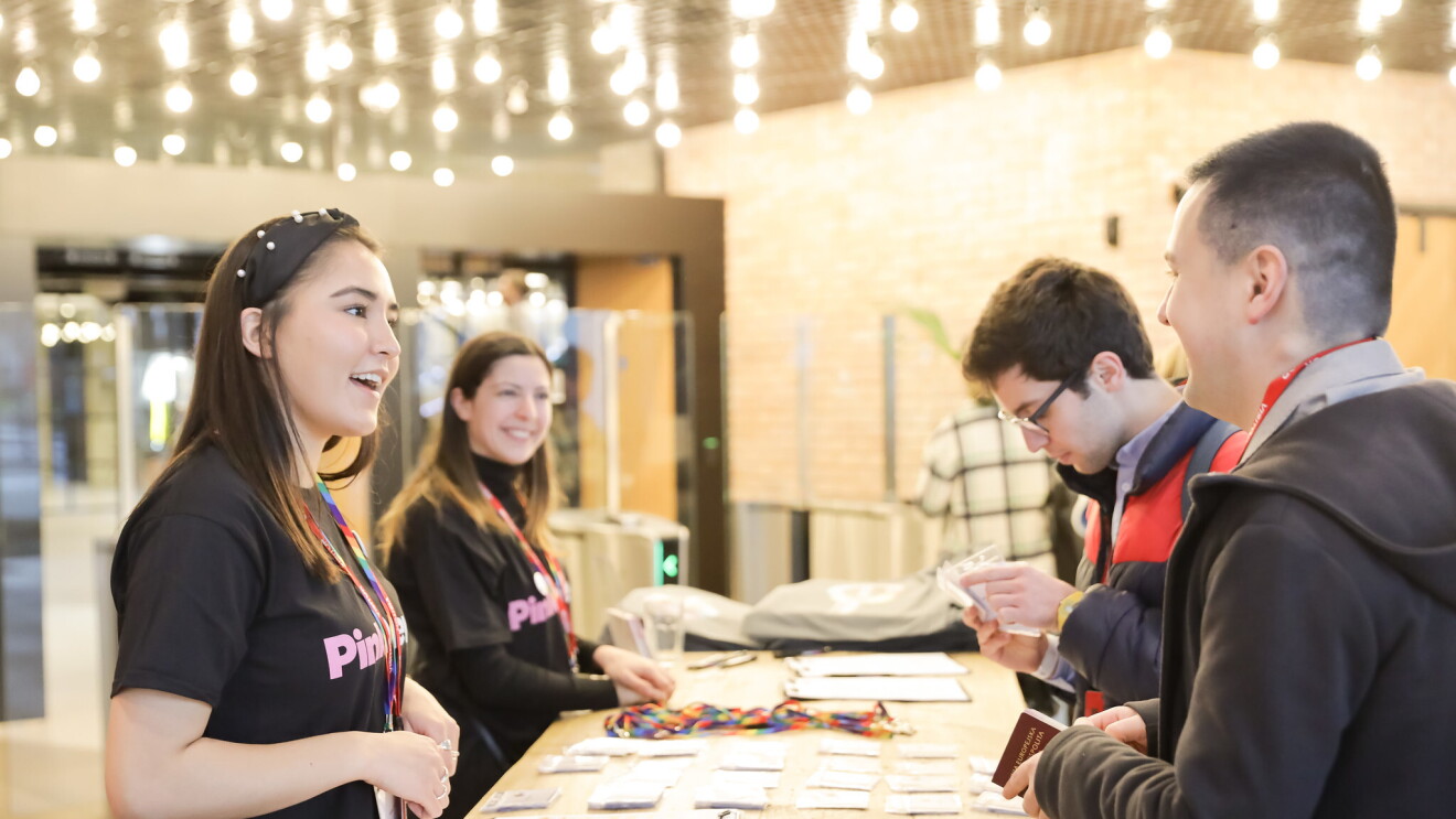 Visitors receiving entry passes for the LGBT Leaders in Stem event at the reception area of Amazon's London head office. 