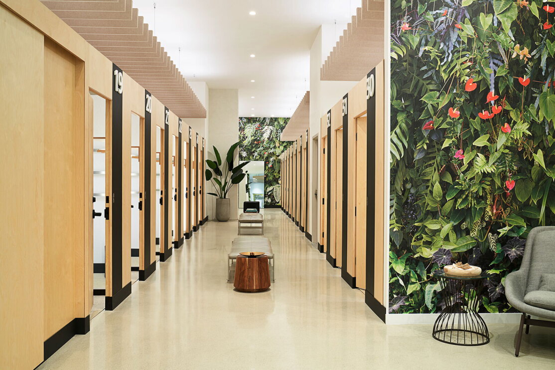 An image of a hallway with two rows of fitting rooms.