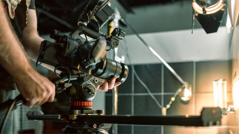 Cinematographer operating professional camera on set