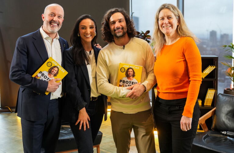 Four people smiling whilst holding Joe Wicks' new cookbook