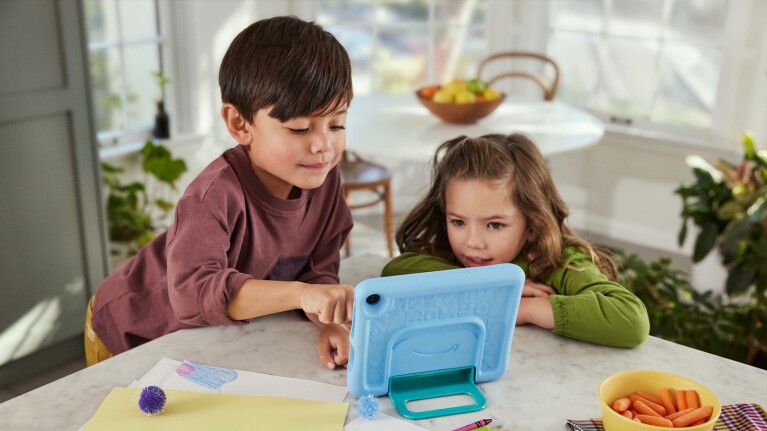 An image of two kids using an Amazon tablet.