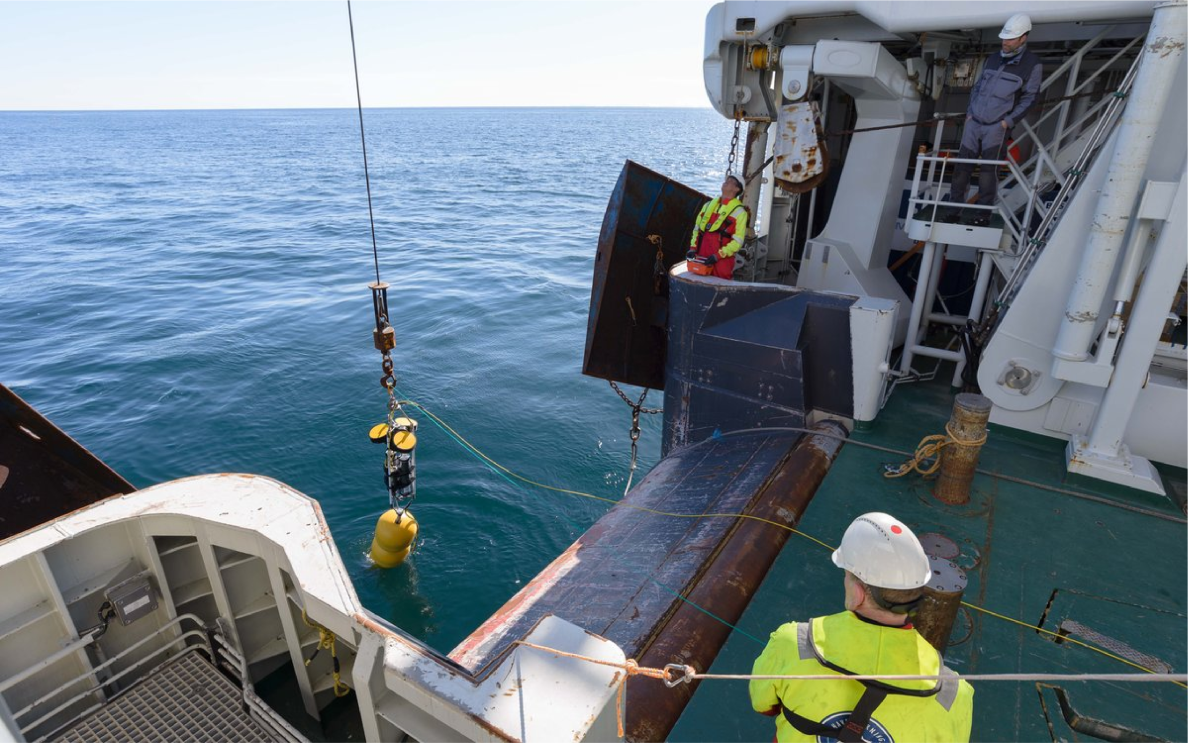 Boat at the LoVe Observatory in Norway, team collecting data and bringing up the underwater sensors.