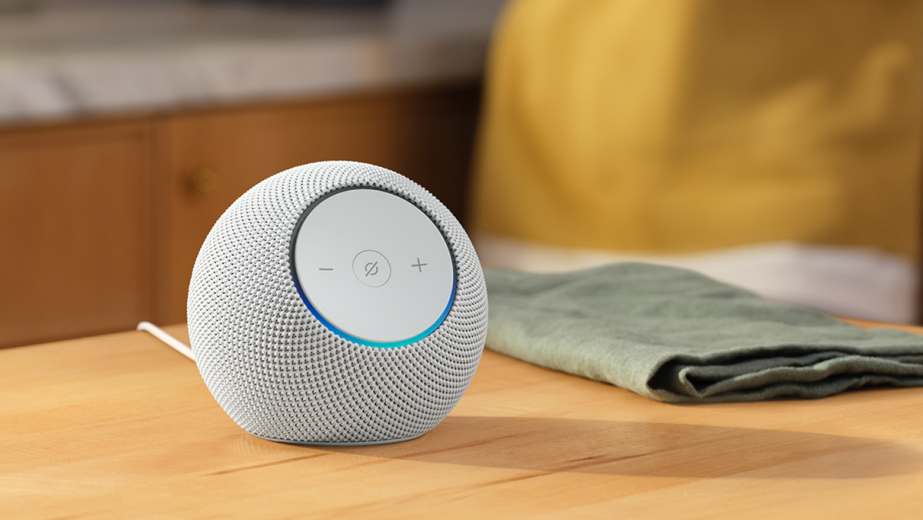 Amazon Echo Dot Max sur une surface en bois avec une lueur colorée
