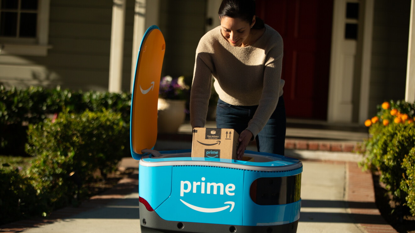 A woman retrieves her package from Scout in front of a home. 