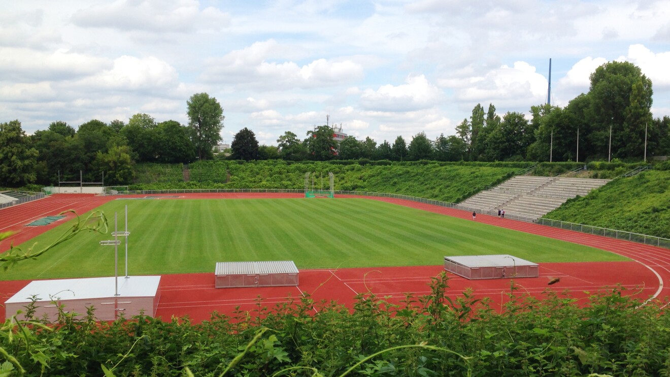 Ein Stadion mit roter Rennbahn und Rasenfläche in der Mitte ist auf dem Foto zu sehen.
