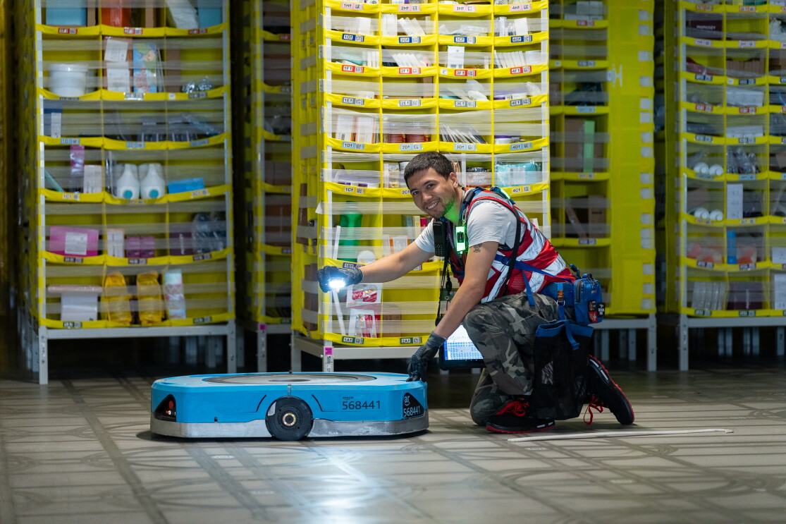 Amazon Mitarbeiter repariert einen Transportroboter