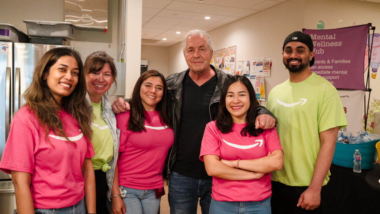 Bret "The Hitman" Hart posing with people in Amazon t-shirts.