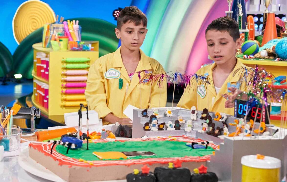 An image of two boys pointing at a Play-Doh sculpture of a stadium from the Amazon Freevee show "Play-Doh Squished."