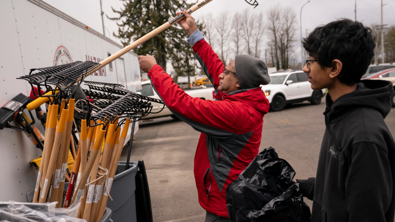 Community cleanup event with volunteer handling garden tools