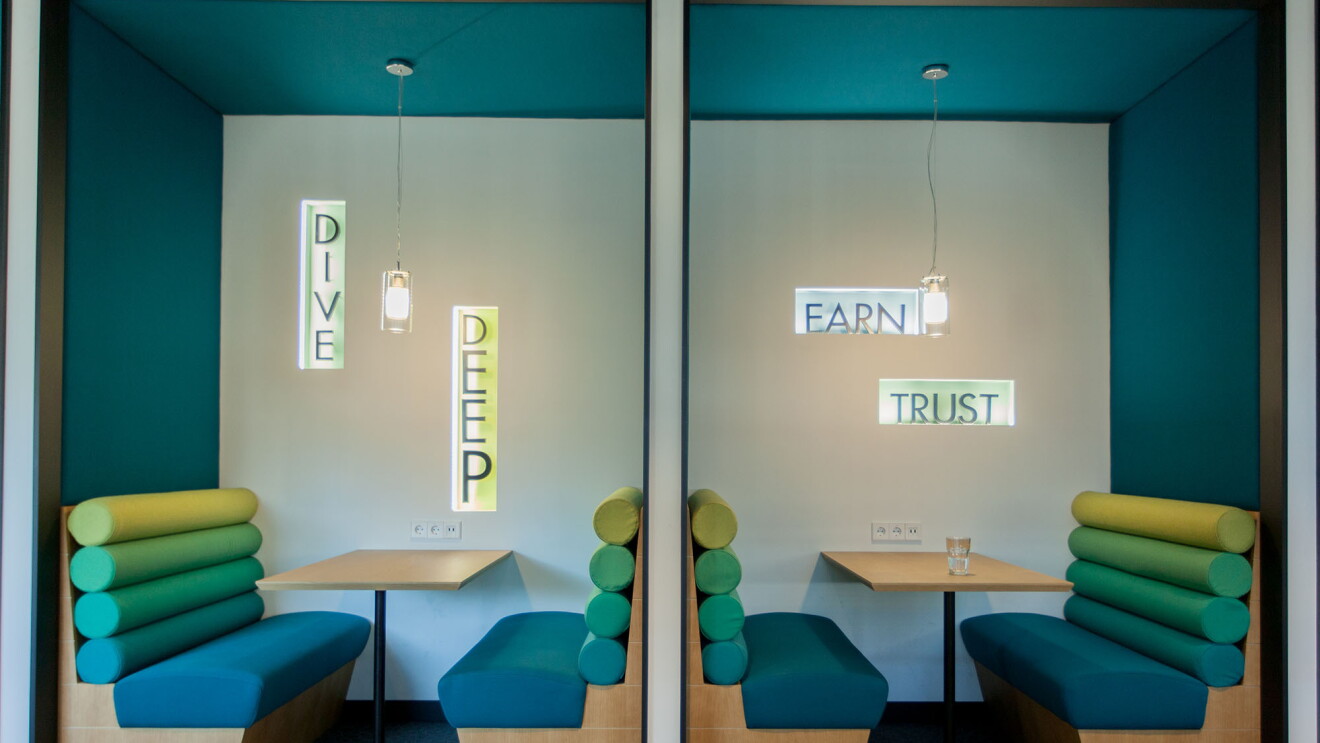 zwei bunte meeting inseln mit den schriftzügen dive deep und earn trust