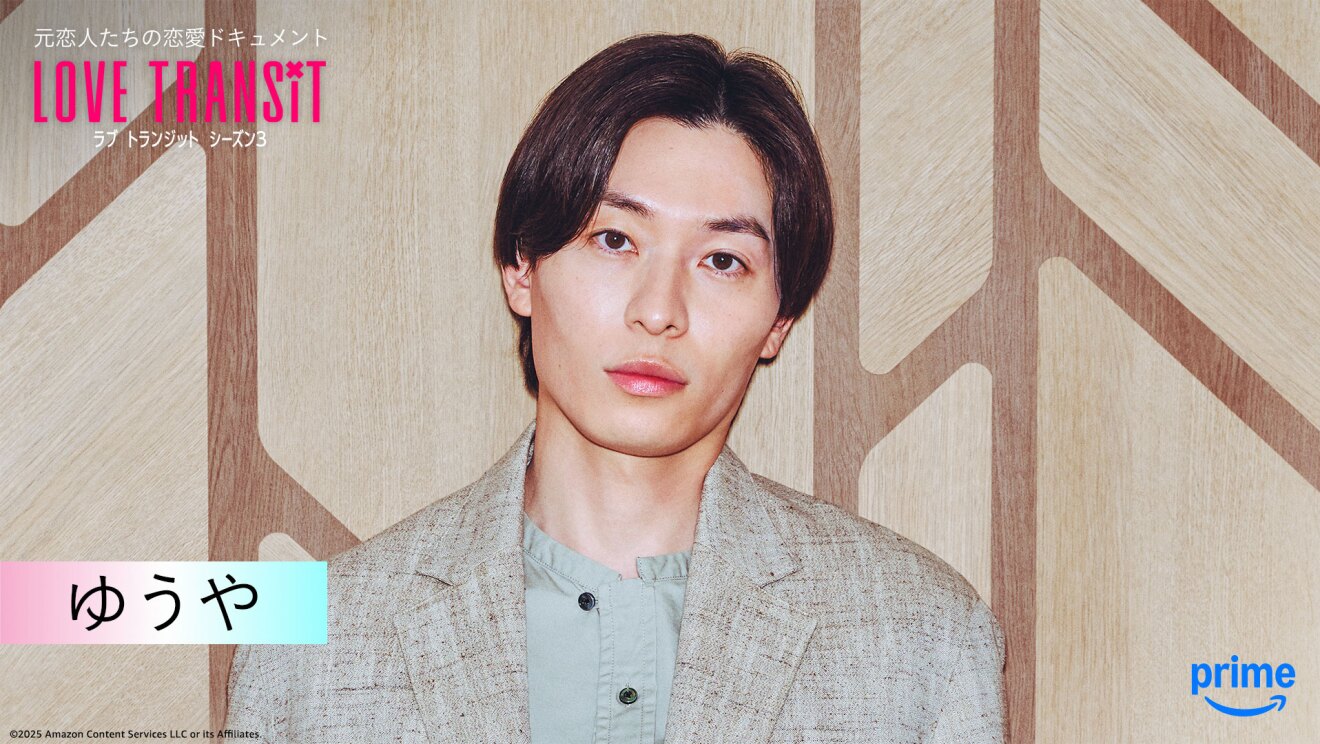 木目調の壁の前に立つ人物のバストアップ。左上隅に「LOVE TRANSIT」の文字。左下に「ゆうや」と名前が表示されている。