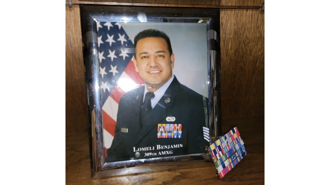 A picture frame with an image of Benjamin in his Army gear.