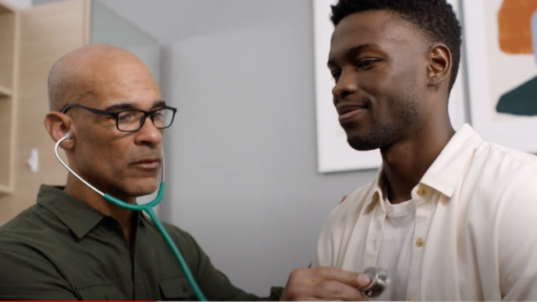 A doctor listens to a patients heartbeat using a stethoscope at a health care clinic.