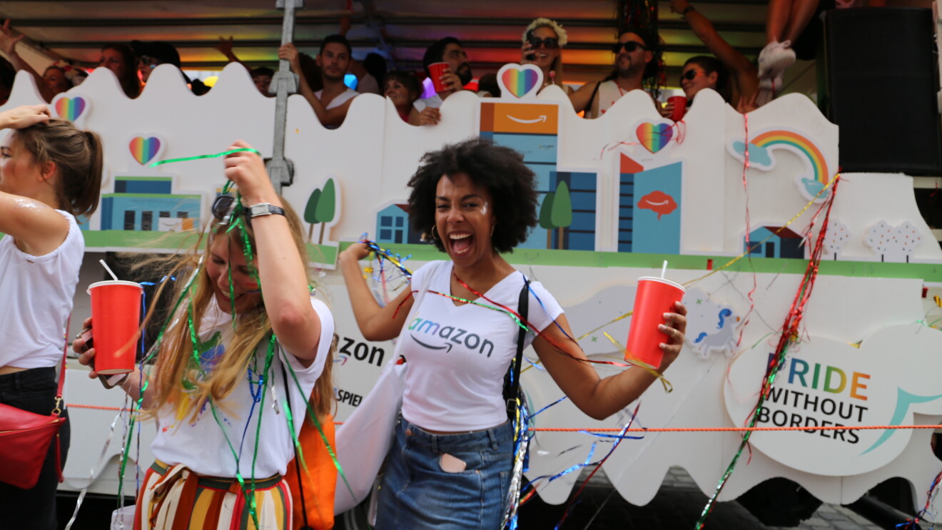 Feiernde Amazon Mitarbeiter vor dem Glamazon-Wagen auf dem Christopher Street Day in München.