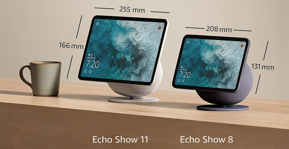 木製の台の上に、マグカップと2台のディスプレイデバイス。左の白いデバイス下側に「Echo Show 11」、右の黒いデバイス下側に「Echo Show 8」という記載。どちらも画面には海の写真と時刻表示。