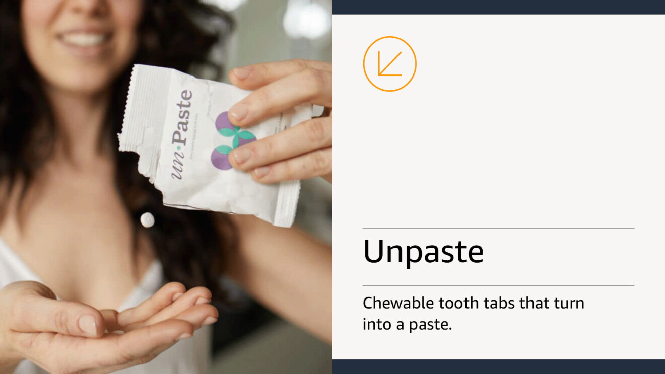 Woman holding up a small paper package and dispensing a small white tablet into her hand