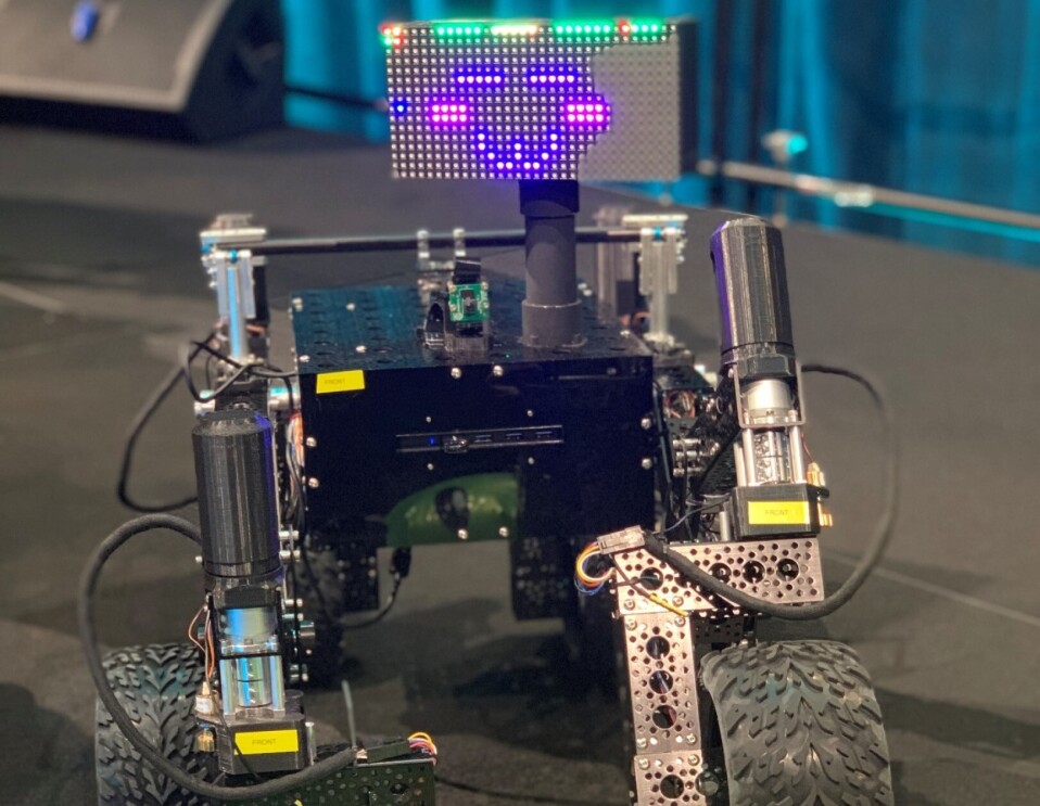 A small robot with wheel feet and an LED face