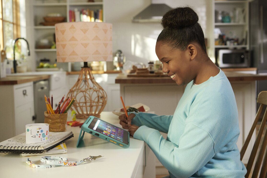 An image of a child using Amazon's Kids Fire Tablet in their home.