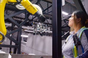 An Amazon employee looks up at a robotic system in a fulfillment center.