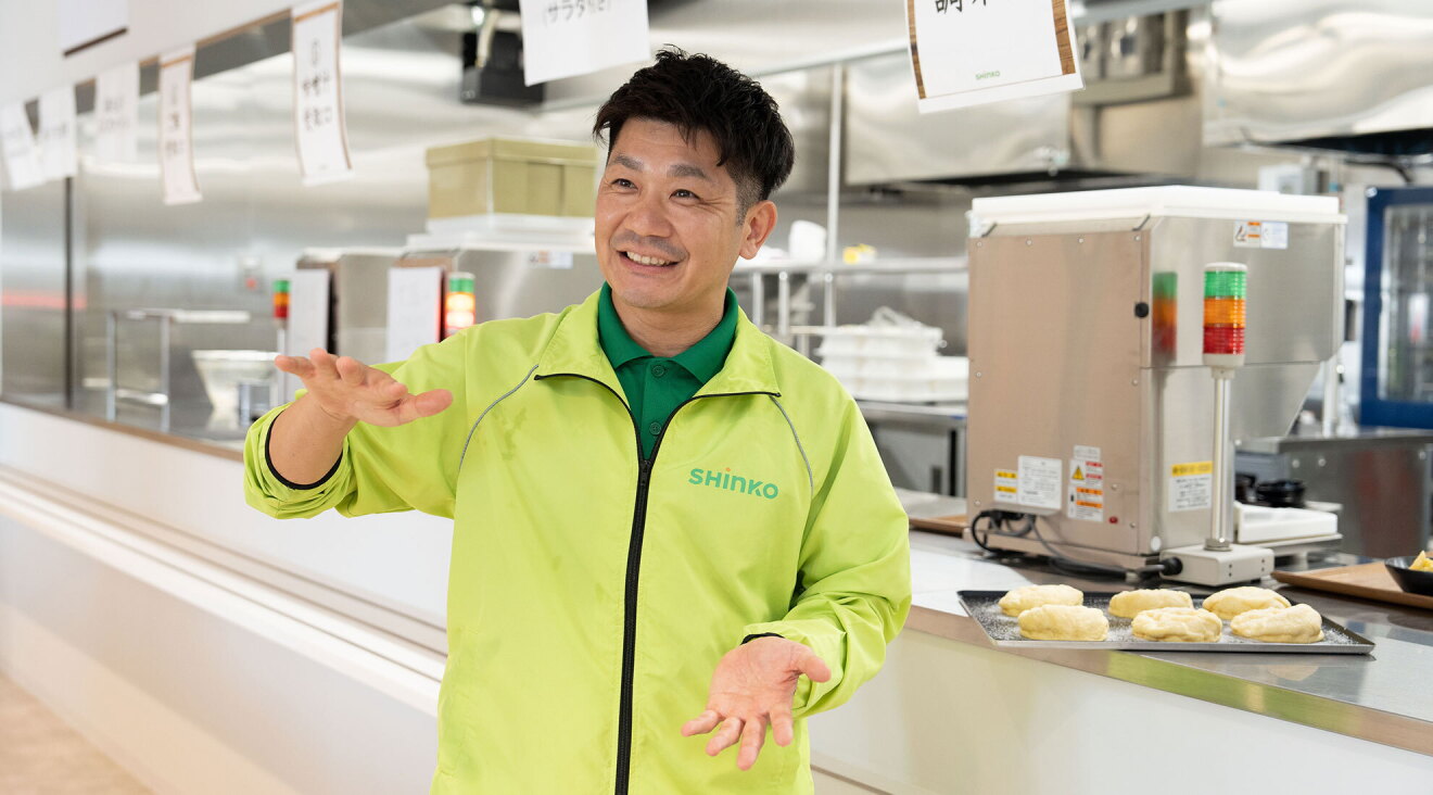 食堂の前で話をする男性