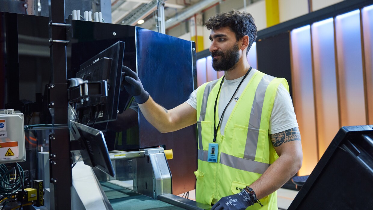 Trabajador de Amazon en un centro logístico robotizado.