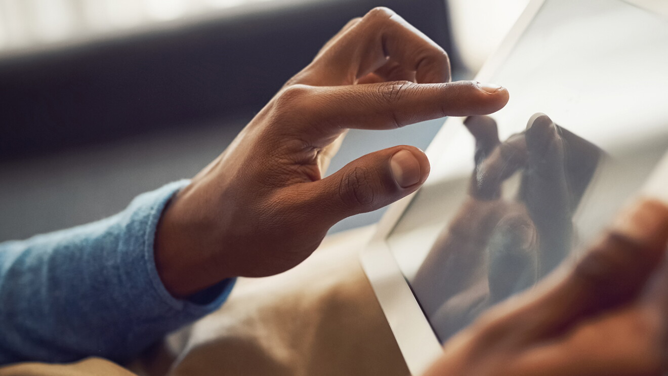 A man touches his tablet as he shops online.