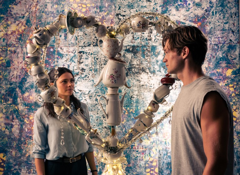 Künstlerische Teekanneninstallation in Herzform, betrachtet von James und Ruby