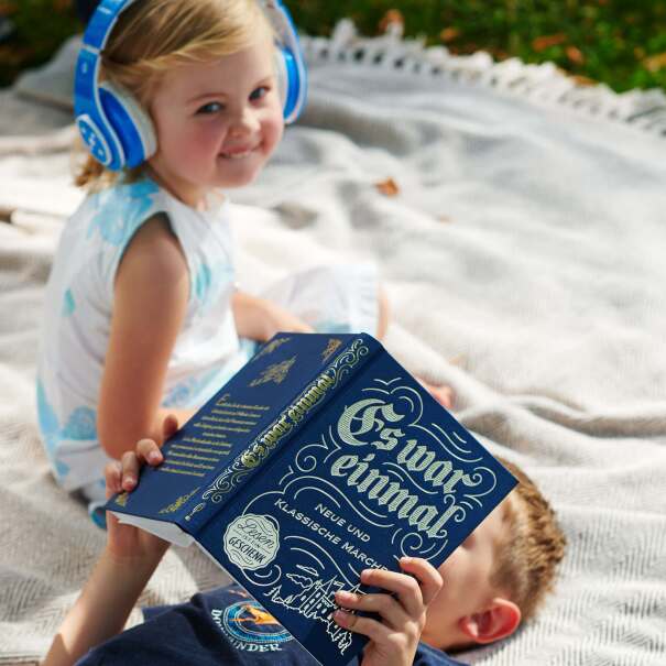 Kinder Lesen Märchen auf einer Picknickdecke