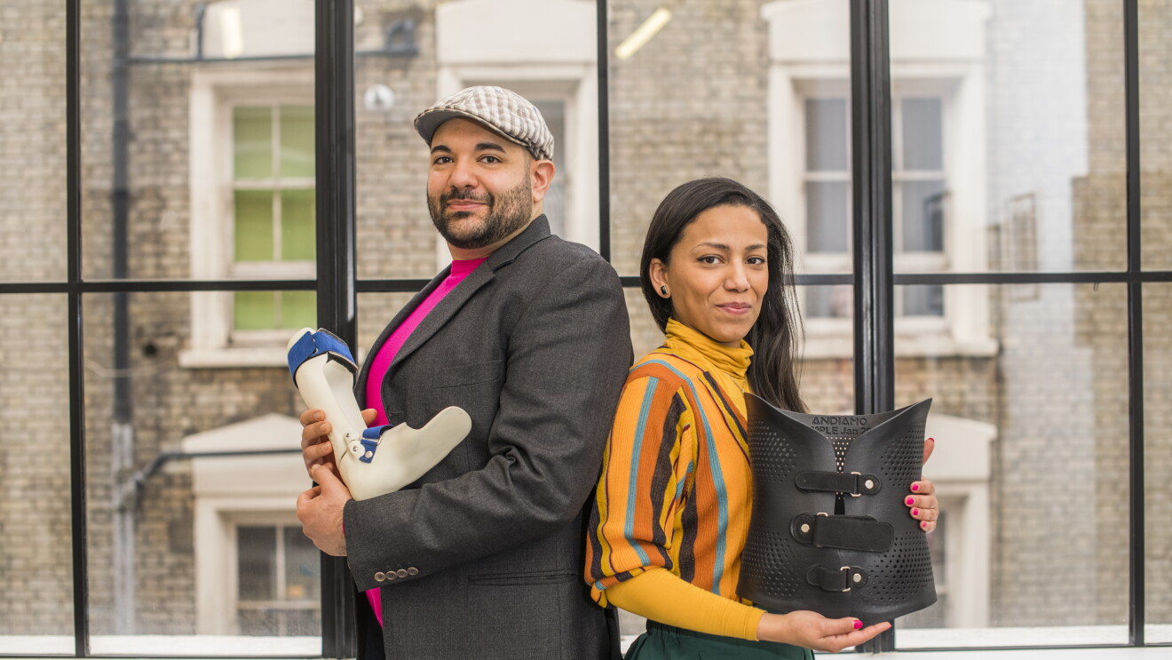 A photo of Naveed and Samiya Parvez, back to back, smiling and displaying two of the custom-made orthoses produced by their startup Andiamo: a device for the back and one for the ankle.