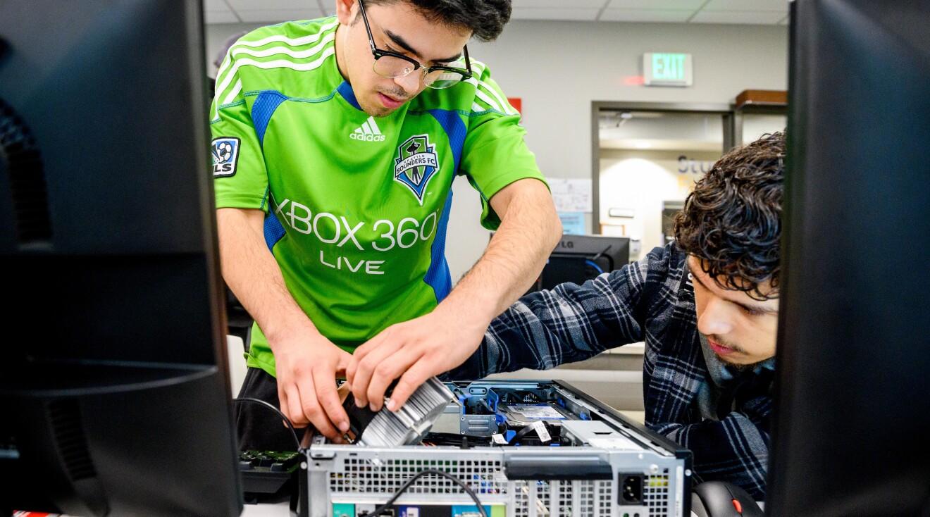 A photo of two students building a computer on a desk.