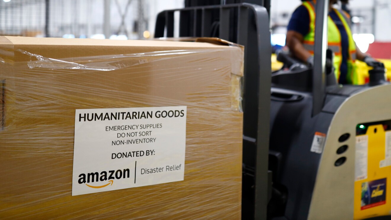 Katastrophenhilfe von Amazon: Auf einem Gabelstapler ist ein großer Karton zu sehen, beschriftet in englischer Sprache: Humanitarian goods. Emergency supplies. Do not sort. Non-inventory. Donated by: Amazon Disaster Relief.
