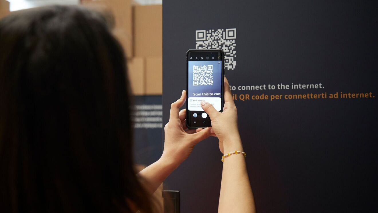 A person holds their phone to a QR code to scan