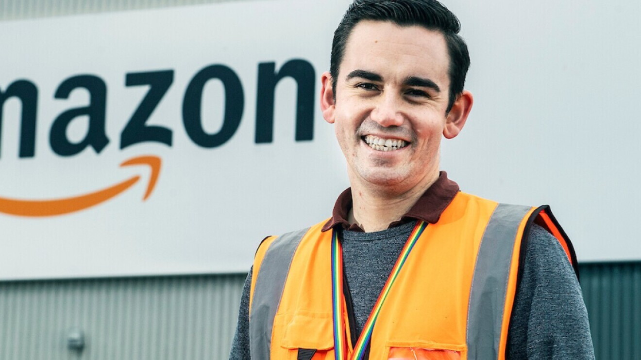 Amazon staff member in front of fulfilment centre