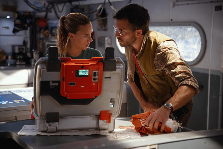 Scientists examine equipment in high-tech lab environment