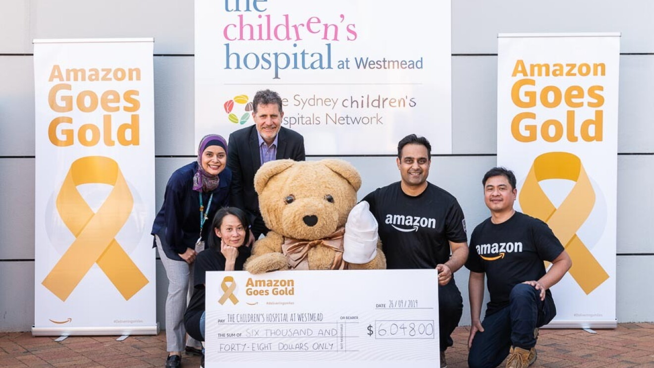 Amazon employees present a $6,048 check to The Children's Hosital at Westmead.