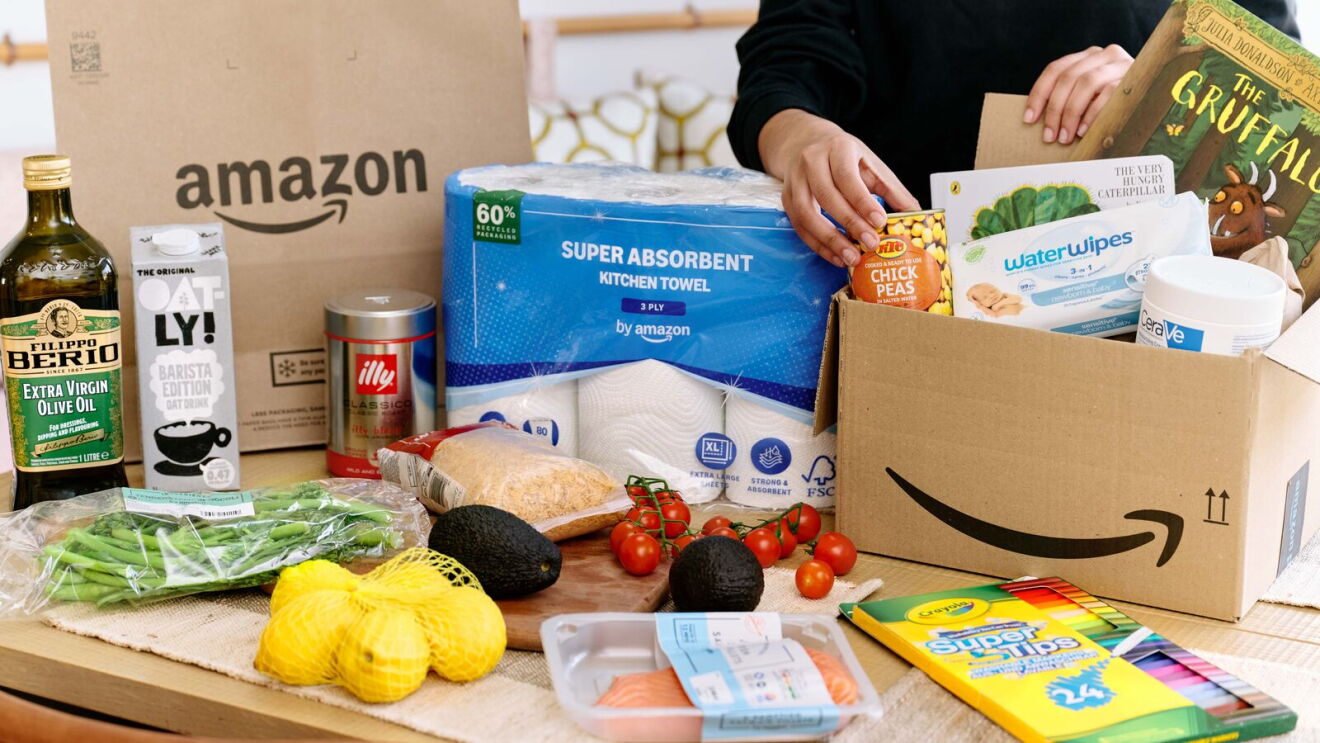Assorted groceries and household items arranged in front of an Amazon delivery packaging