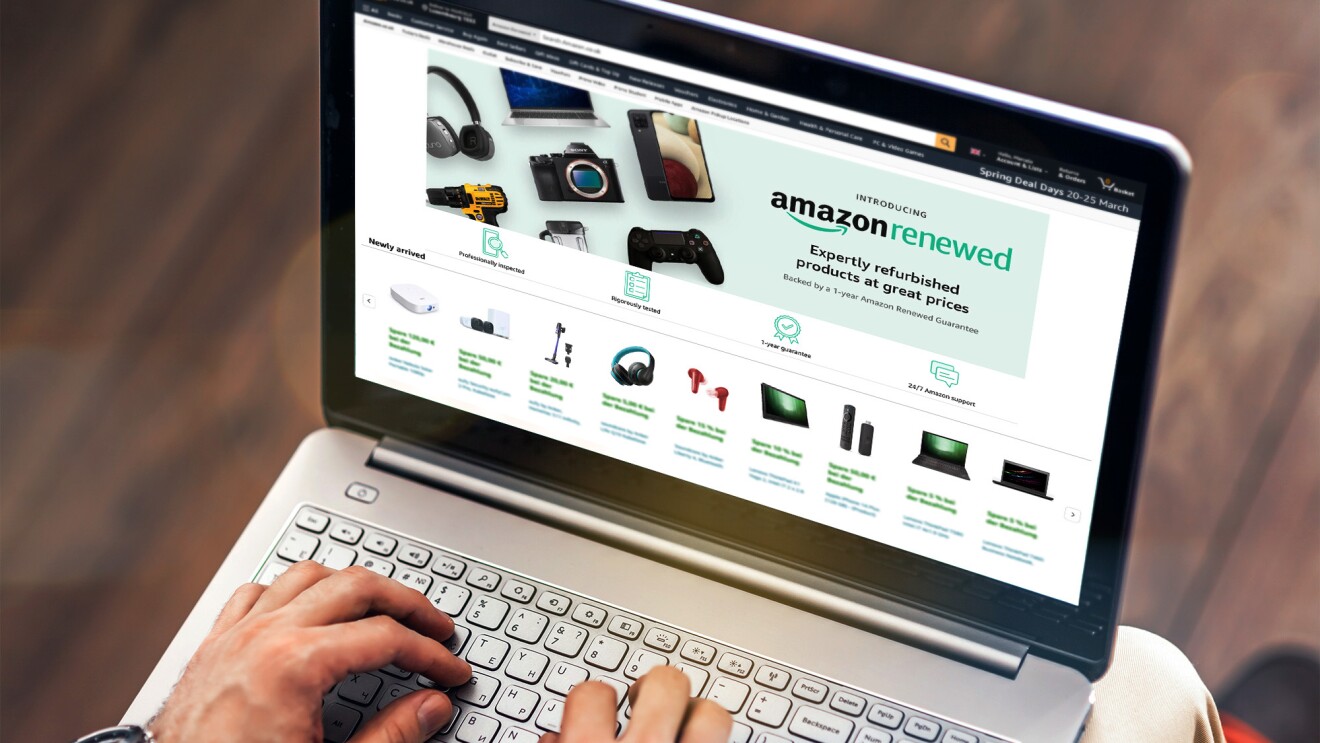 Computadora portátil junto a un teléfono móvil y una taza de café, mostrando el escaparate de Amazon Renewed