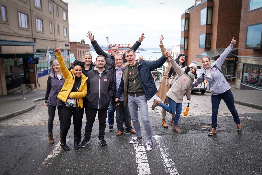 Group shot of Amazon employees on the 'I Found the Right Place' programme in Seattle, they are outside of a market.