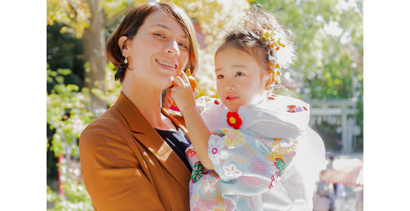 晴れ着を着たお子さんを抱き、笑顔の越知さんの写真