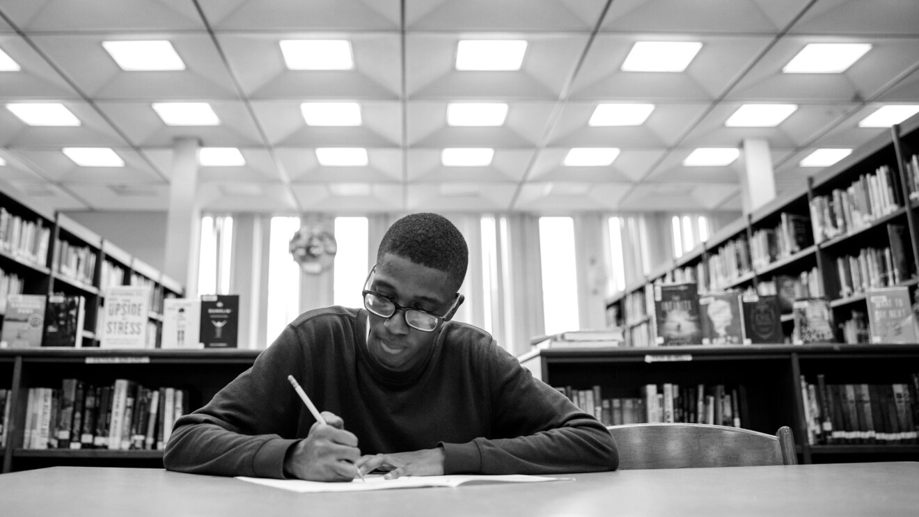 Amazon Future Engineer student studying at a desk in the library.