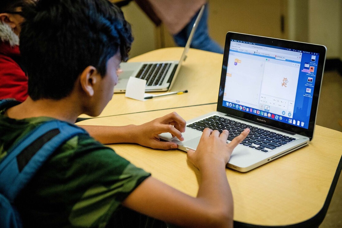 Students work on coding programs on laptop computers in a classroom at a New York City school. 