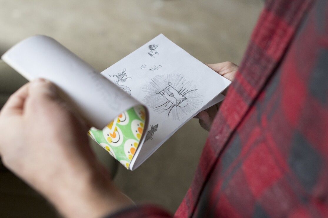 Amazon artist Kyler Martz flips through a sketch book.