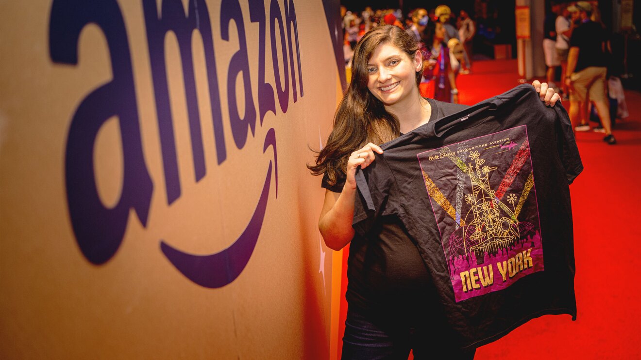 an image of Tara holding up one of the travel poster shirts that shows New York